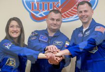 Three Soyuz MS-12 crew members in blue flight suits in a recovered archival thumbnail